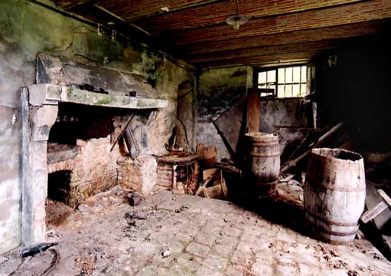 La cuisine en sous-sol. Le four � pain se trouve sous le manteau de la chemin�e.